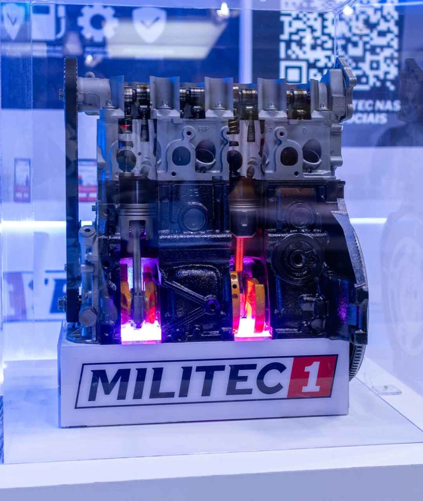 Motor aberto em funcionamento com Militec 1 aplicado durante o Salão do Automóvel 2025